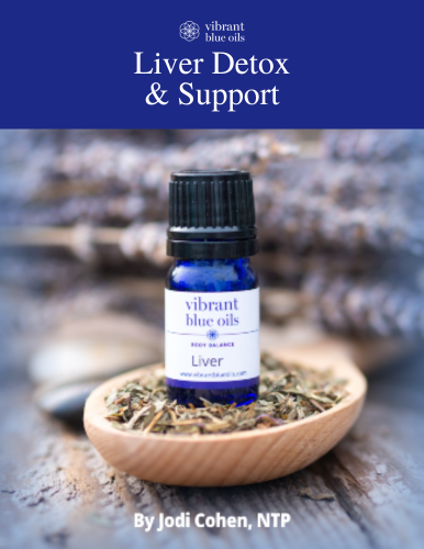 An essential oil bottle branded "vibrant blue oils" prominently placed on a wooden spoon filled with dried herbs, with a blurred out background emphasizing the product and suggesting a health and wellness theme related to liver detox and support.