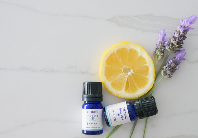 A calming flat lay with essential oils, fresh lemon slice, and lavender sprigs on a marble background, suggesting a serene aromatherapy session.