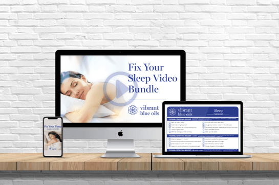 A desktop, tablet, and smartphone display a sleep-related product called "Fix Your Sleep Video Bundle" by Vibrant Blue Oils. The background features a white brick wall, and the devices rest on a wooden surface.